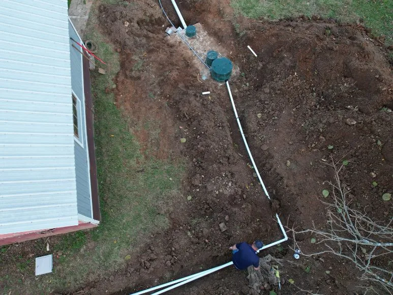 Aerial view of a house with a septic system installation in progress