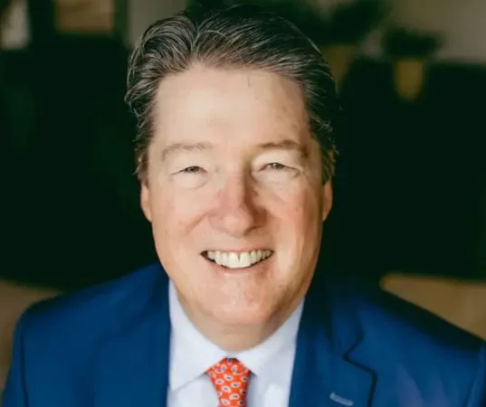 A man in a blue suit smiling at the camera