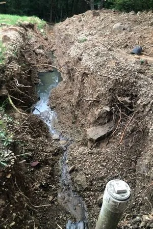 A hole in the ground with dirt and water