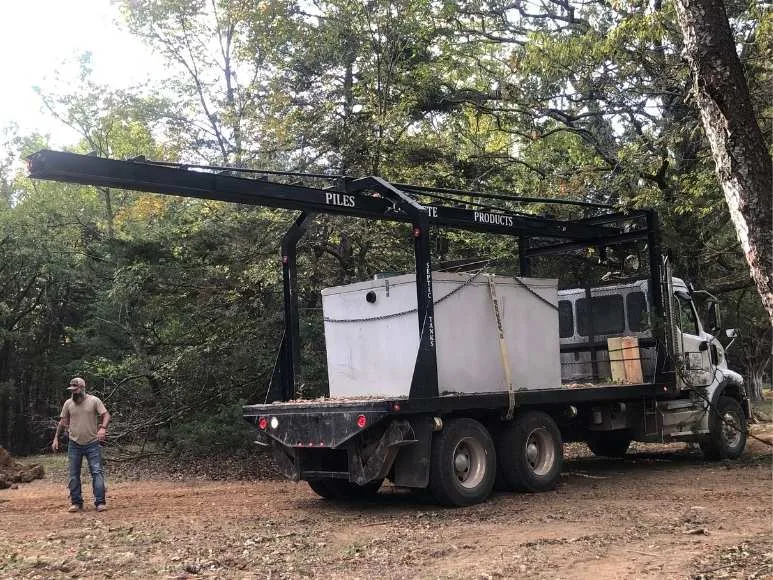 A man in the woods with a large truck